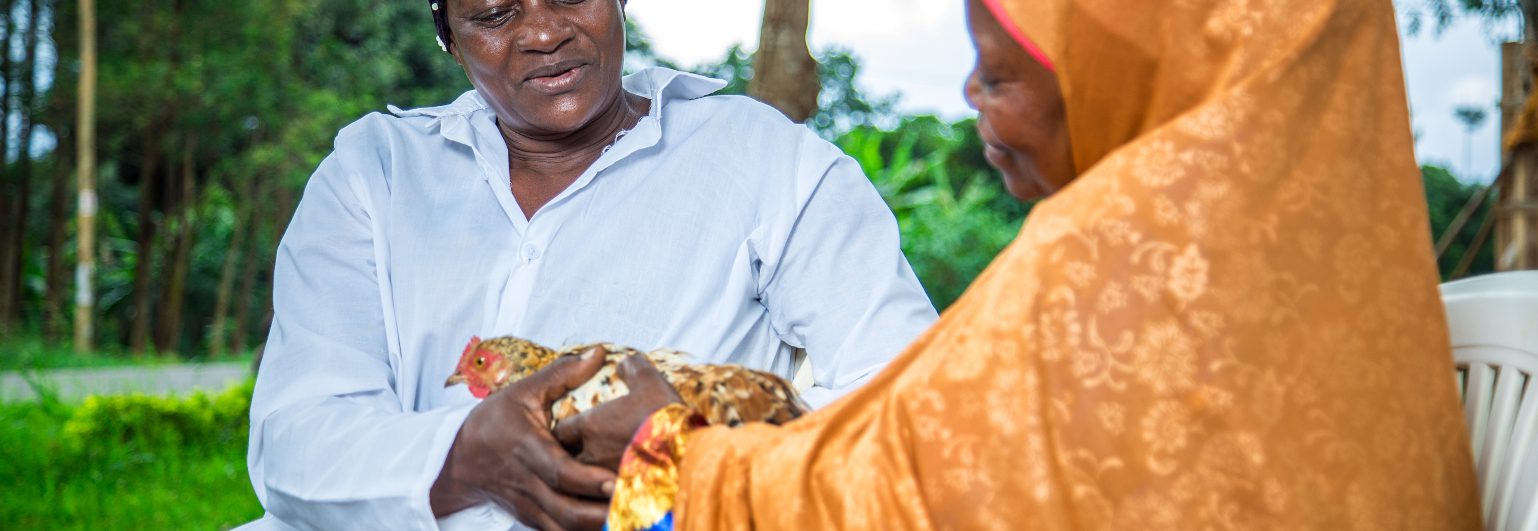 African female farmers with a chicken 1538x531